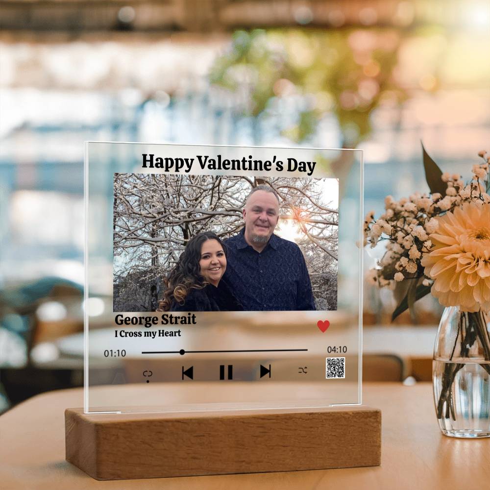 Clear acrylic plaque with a couple's photo, music player interface, and 'Happy Valentine's Day' text on a wooden base.